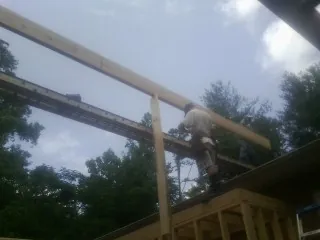 Carpenter setting a ridge beam over a new addition frame — Ice Dam Removal by Roofing Brothers in Lake In The Hills
