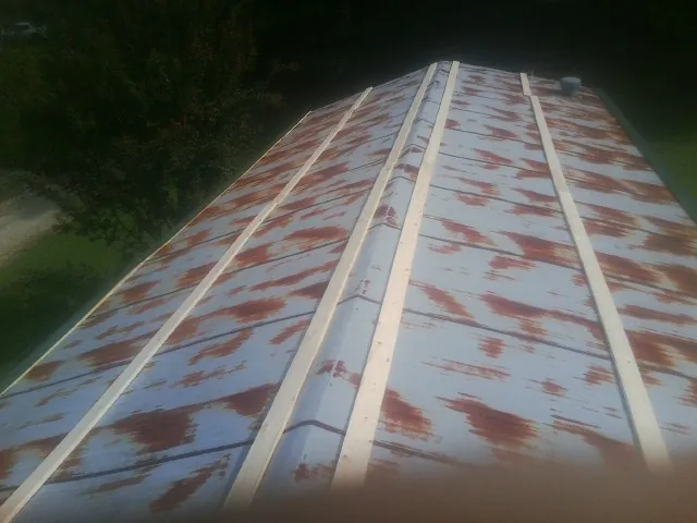 Rusted metal roof panels with new wood purlins before replacement — Storm Damage Roof Repair in Lake In The Hills by Roofing Brothers