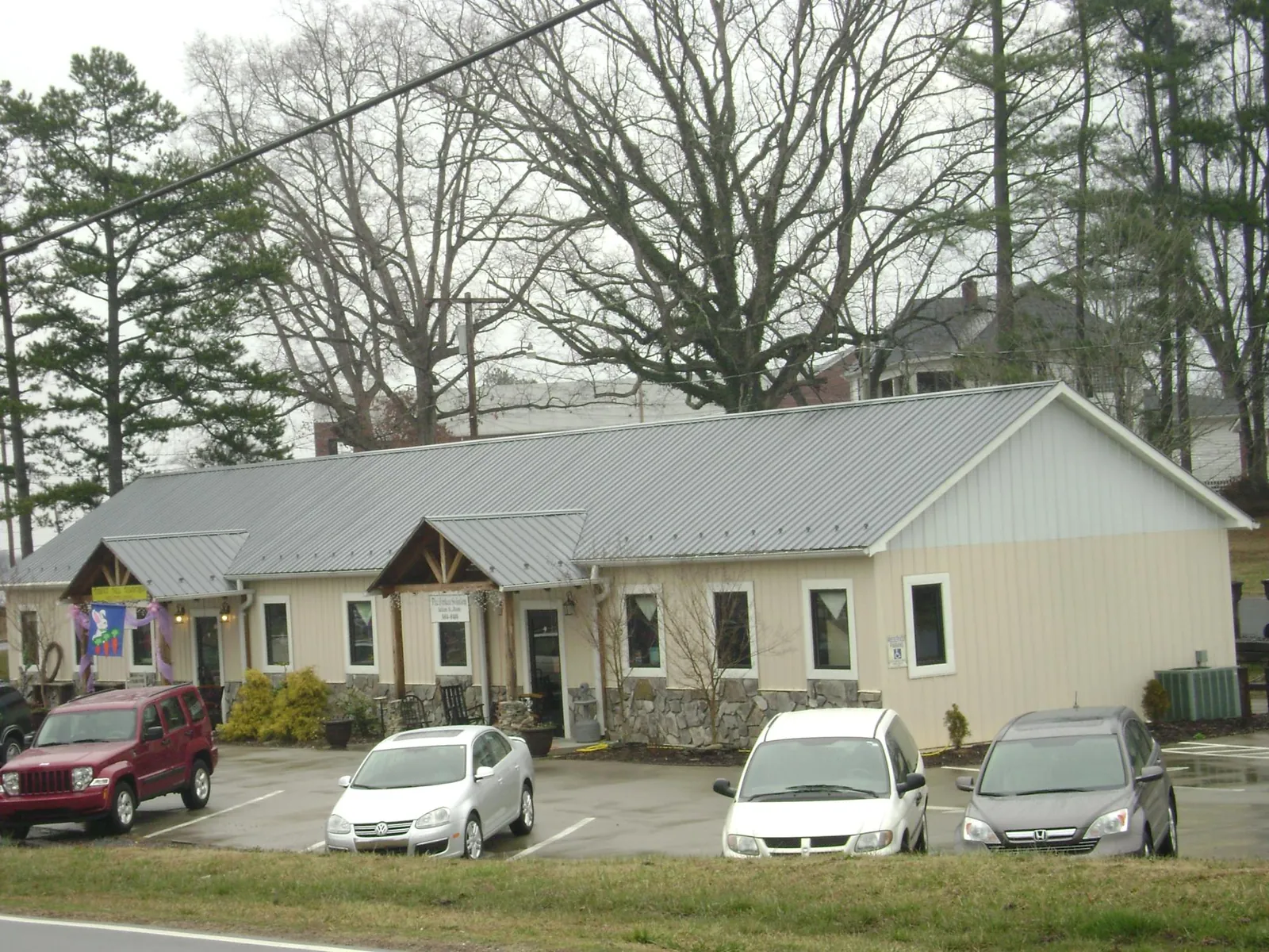 Gray metal roof with timber entry brackets on a small commercial building in Lake In The Hills