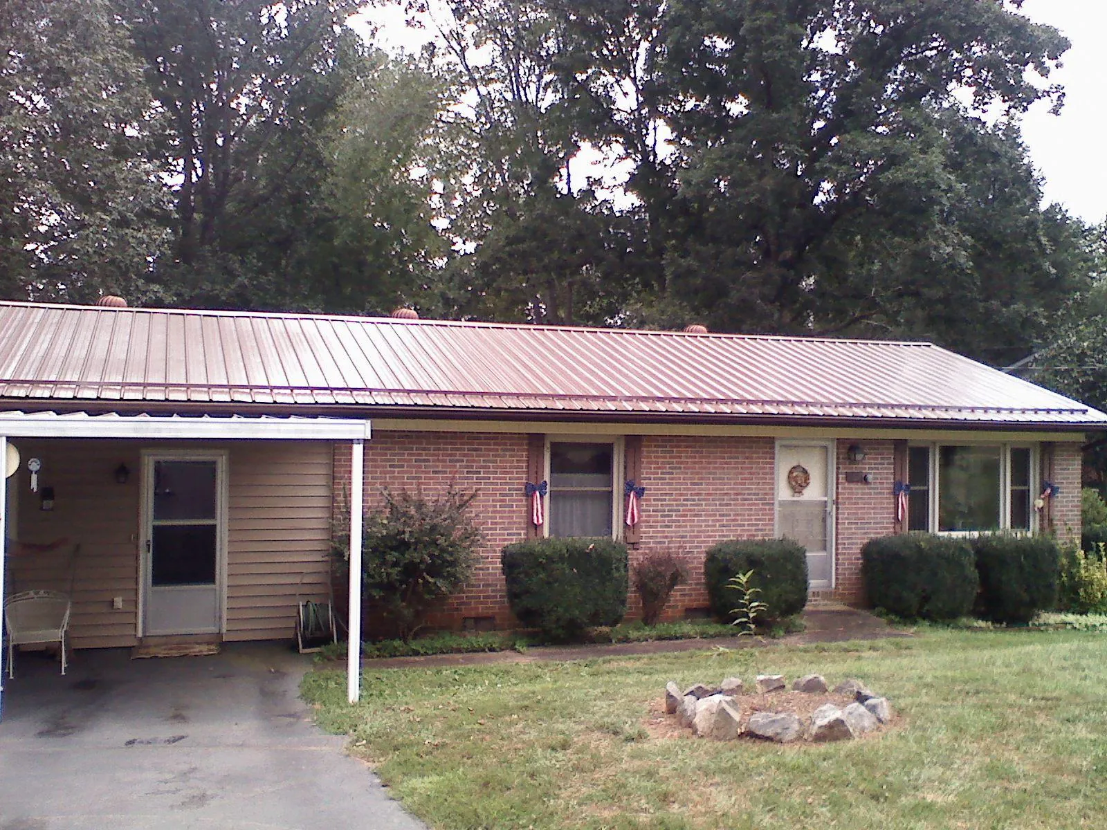 Bronze metal roof and carport on a brick ranch home — Roof Repair work by our crew in Lake In The Hills